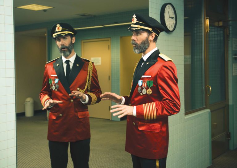 Captain Obvious wearing a red captain suit and black captain hat standing in front of the mirror talking to his reflection for a viral and funny ad campaign for Hotels.com