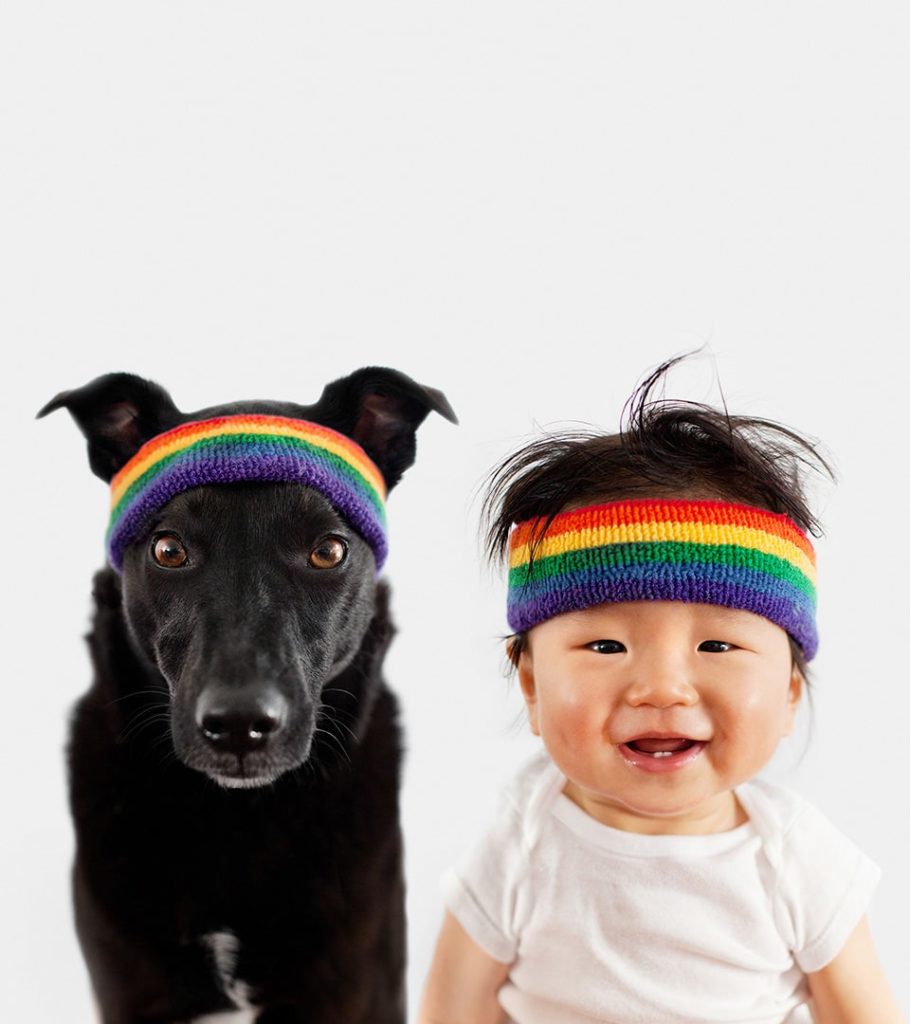 Commissionable artist Grace Chon's cute portrait photography of a smiling asian baby next to their best friend, a black dog.