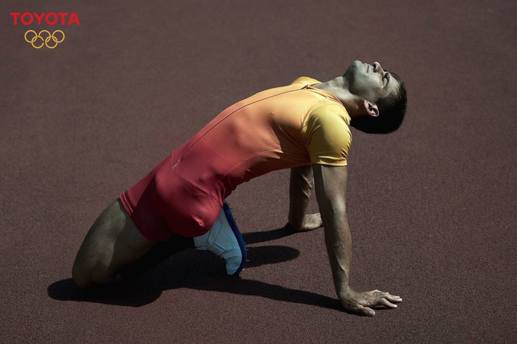 Male Paralympic Olympics athlete stretching on track for Toyota campaign photographed by commissionable artists, Wade Brothers.